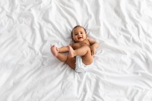 top view of little black baby lying on bed at home 2021 09 02 22 25 15 utc scaled 1