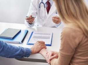 couple in a doctors office holding hands